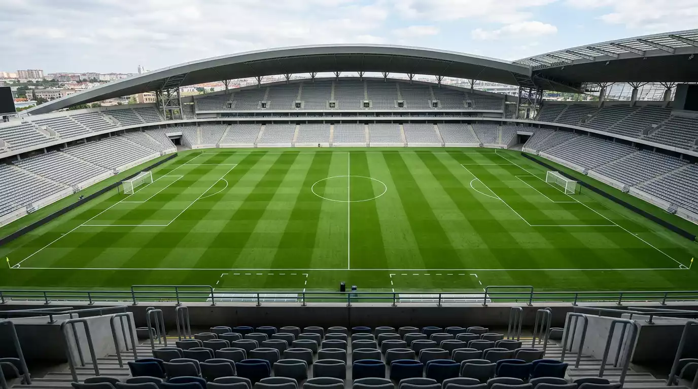 Pizarra táctica y césped de un estadio de fútbol visto desde la grada alta antes de un partido, con las líneas del campo bien marcadas